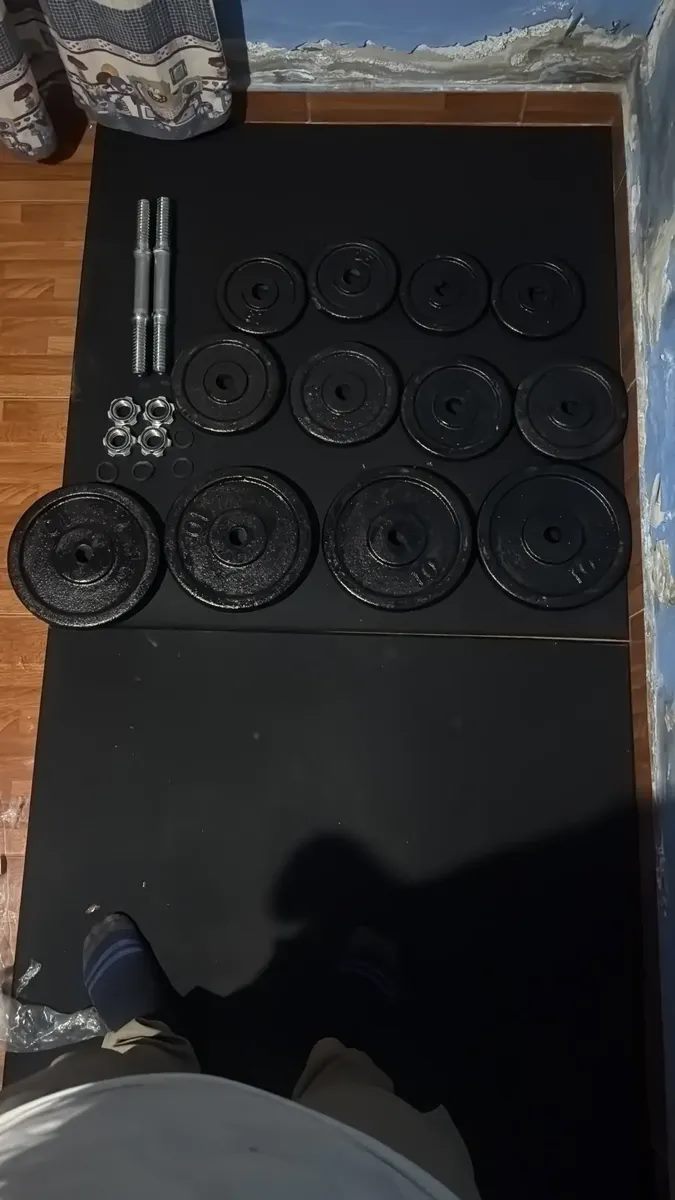 Discos y barras de entrenamiento sobre piso negro