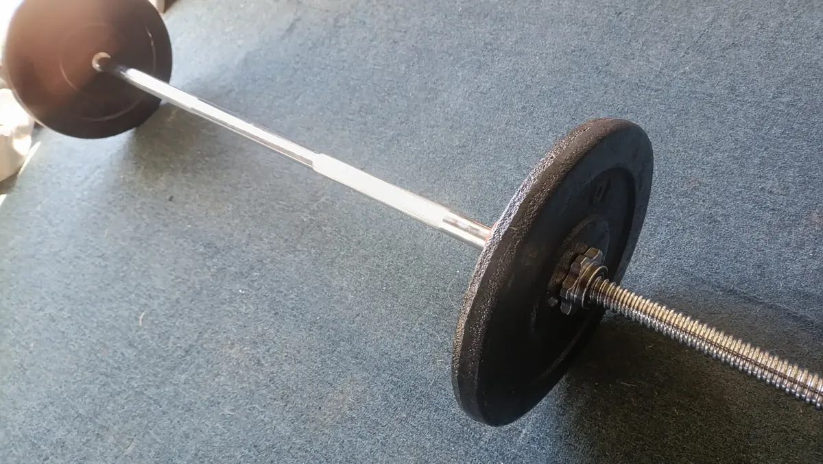 Barra con discos sobre piso gris